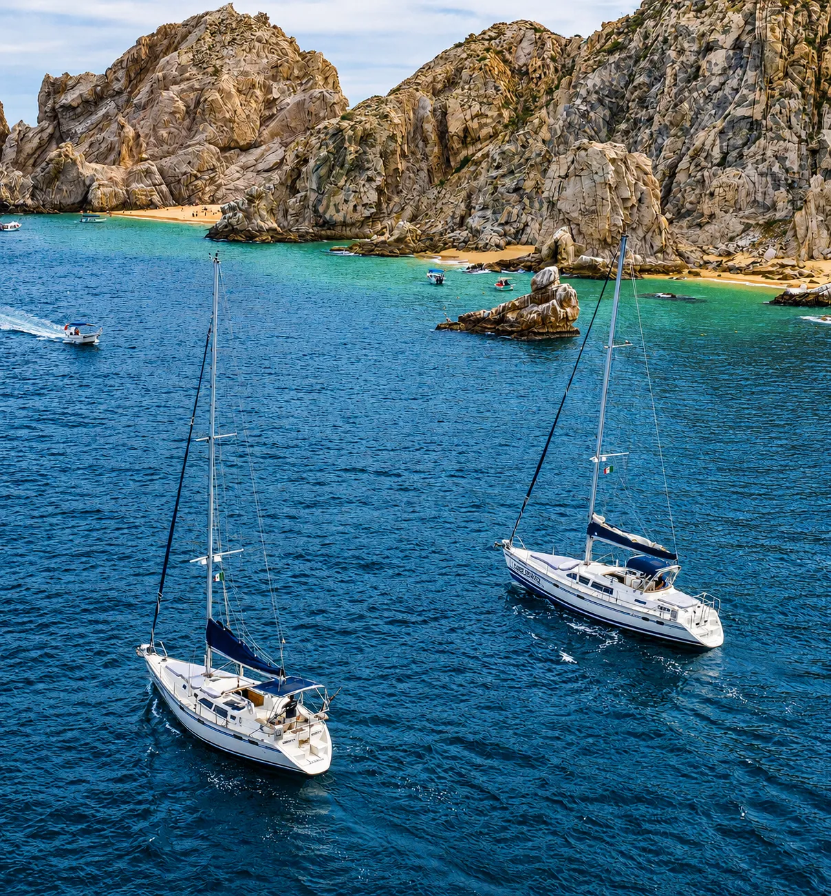 Sailboats passing by Pelican Rock in Cabo San Lucas