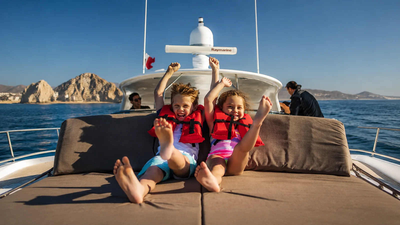 Family enjoying a joyful yacht outing on a sunny day in Cabo San Lucas